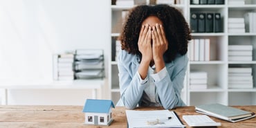  A frustrated woman next to a model home 