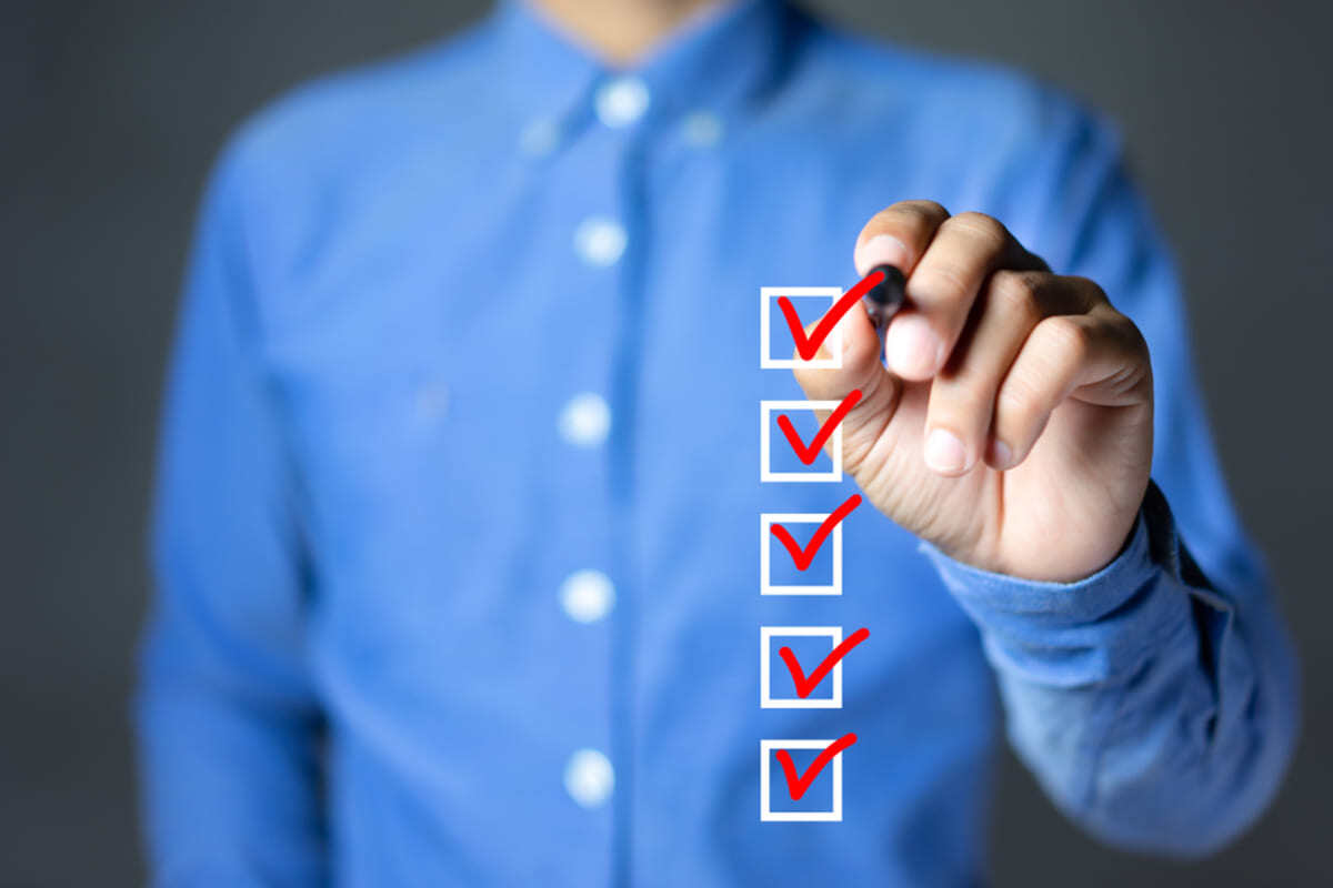 A man in a button-up shirt checking off boxes, roof maintenance checklist concept