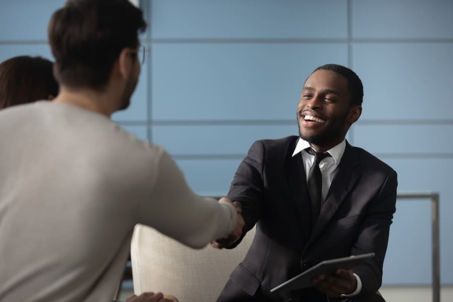 A man in a suit shaking hands with someone