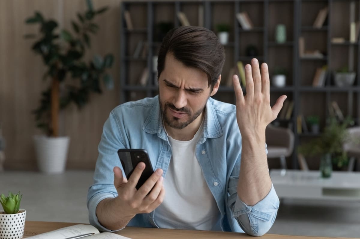 A man looking frustrated at a phone