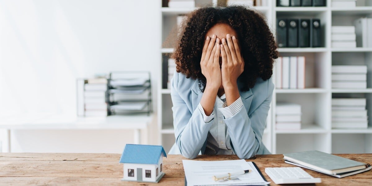 A frustrated woman next to a model home