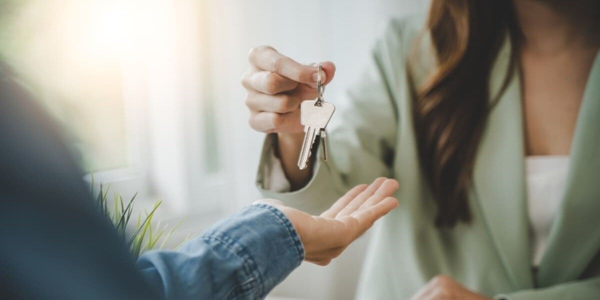 A property manager gives a tenant a key to their new home