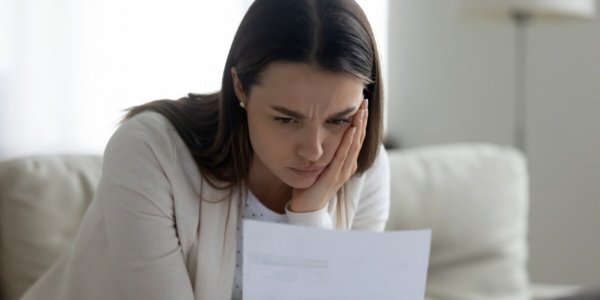 A woman looking at a paper upset