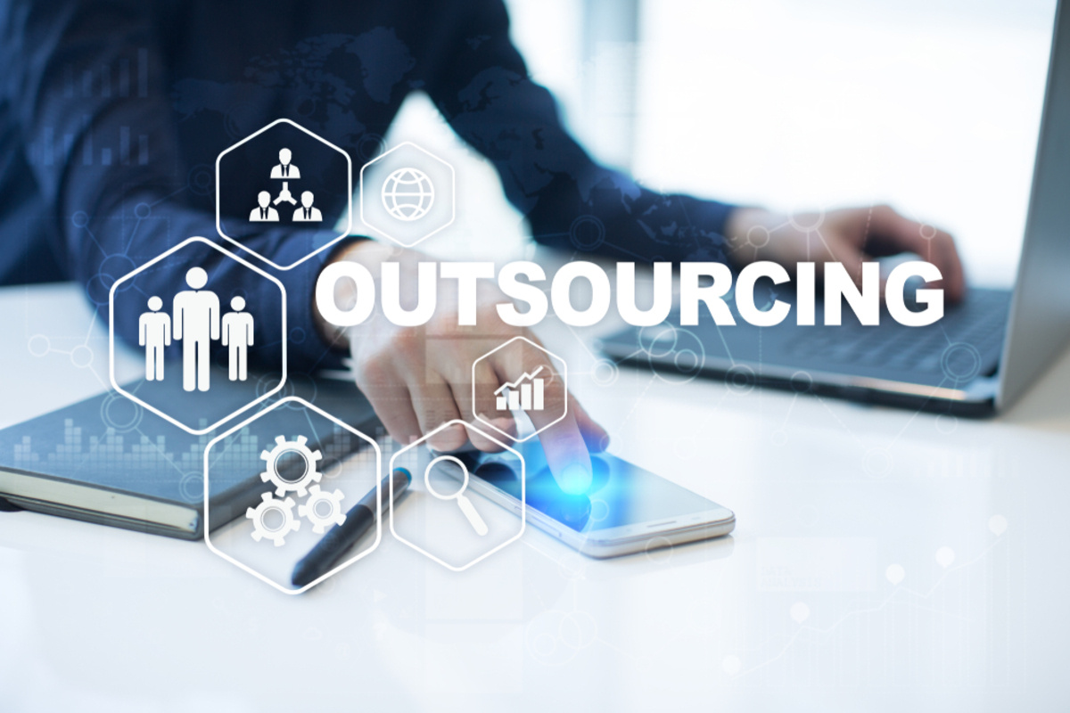 The word outsourcing with icons and laptop background