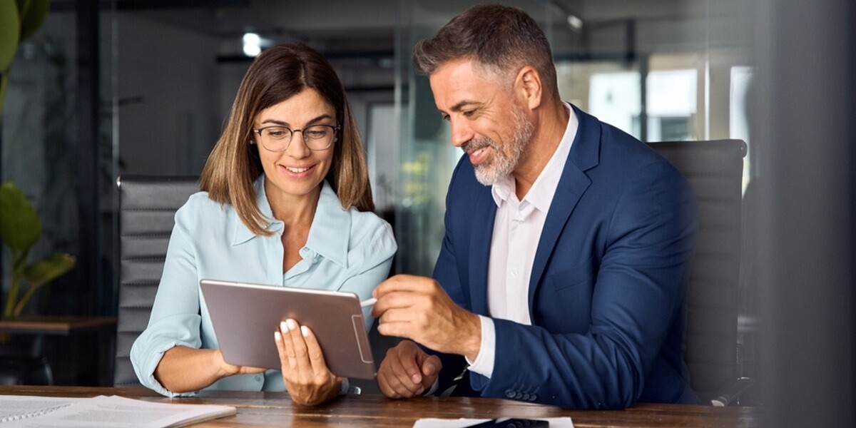 Two professionals looking at a tablet together